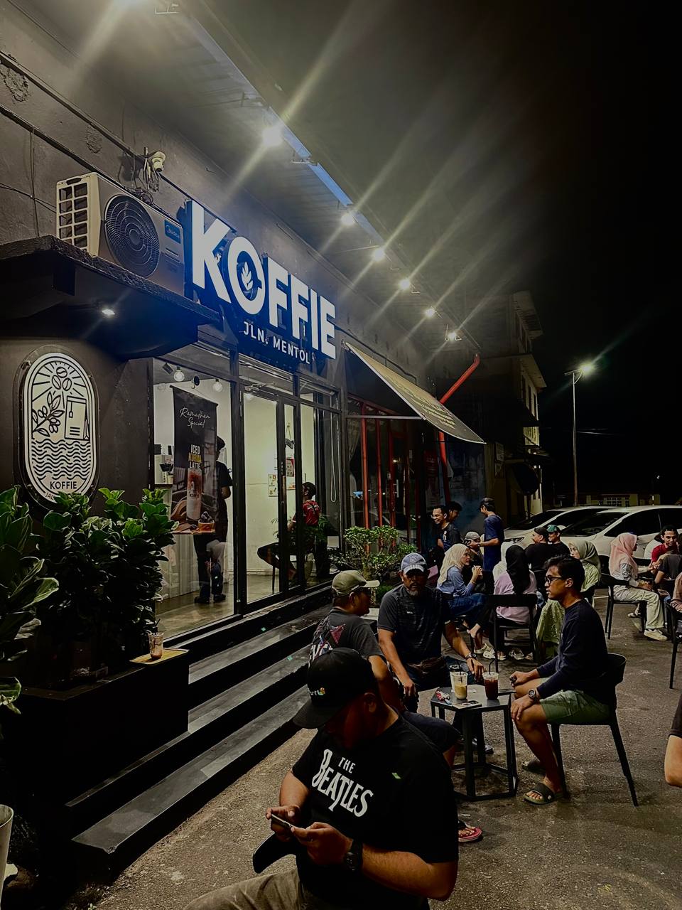 The Koffie Jln. Mentol shopfront lit up at night